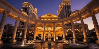 Caesars Palace Las Vegas exterior at twilight with illuminated Roman architecture and fountain plaza