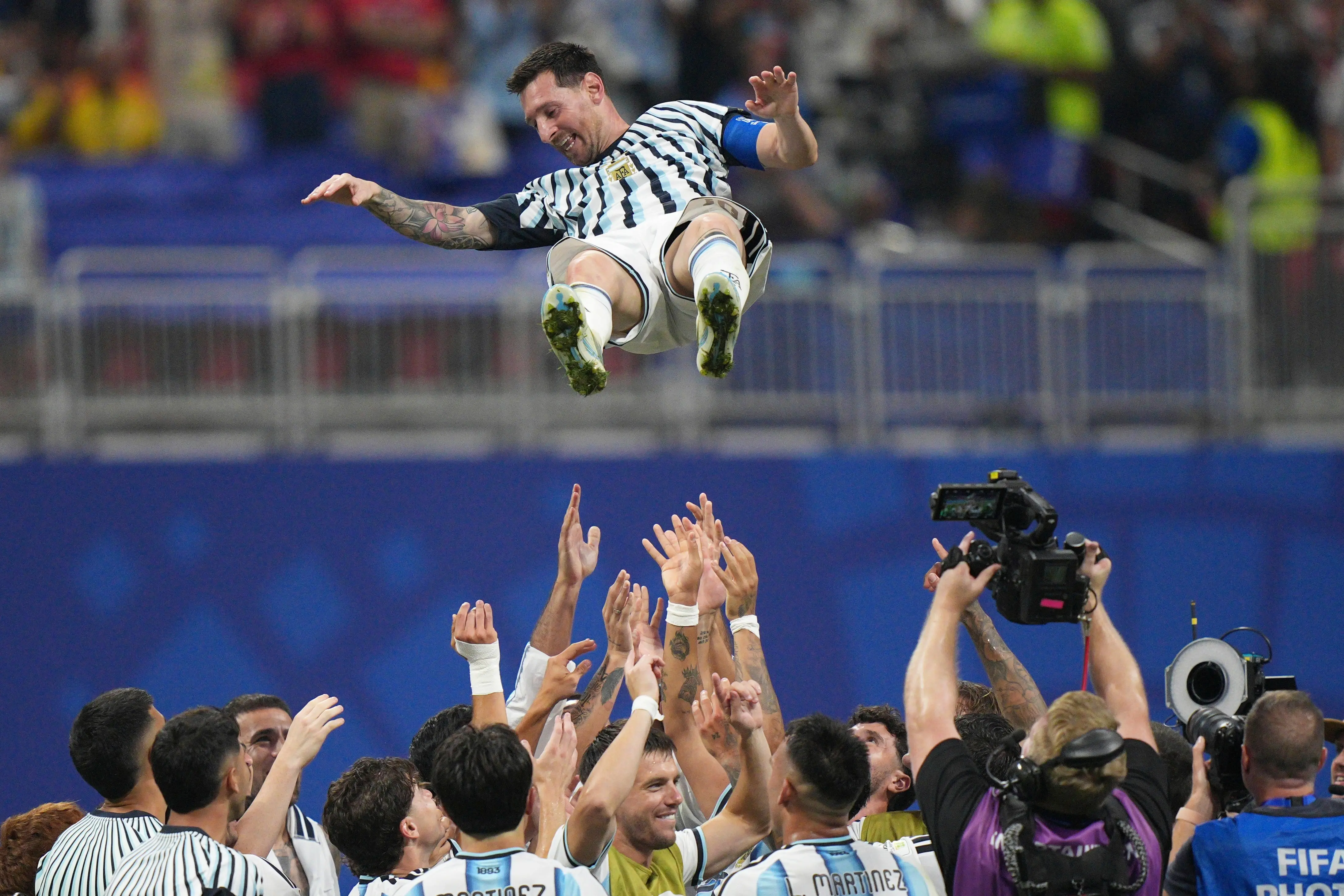A jubilant soccer player is lifted by teammates in celebration during a World Cup match.