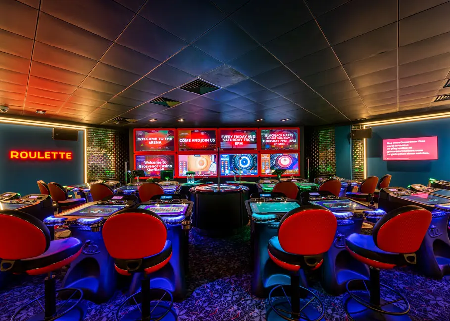 Interior view of Grosvenor Casino gaming area featuring roulette tables and screens.