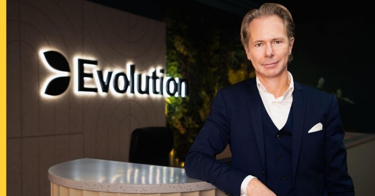 A man in a suit stands at a reception desk with the 'Evolution' logo behind him.