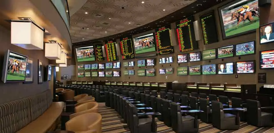 Interior of MGM Grand sportsbook in Las Vegas with multiple screens showing live sports.