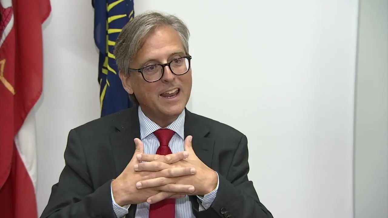 Gibraltar Minister Nigel Feetham speaking with hands gesturing in an office setting.