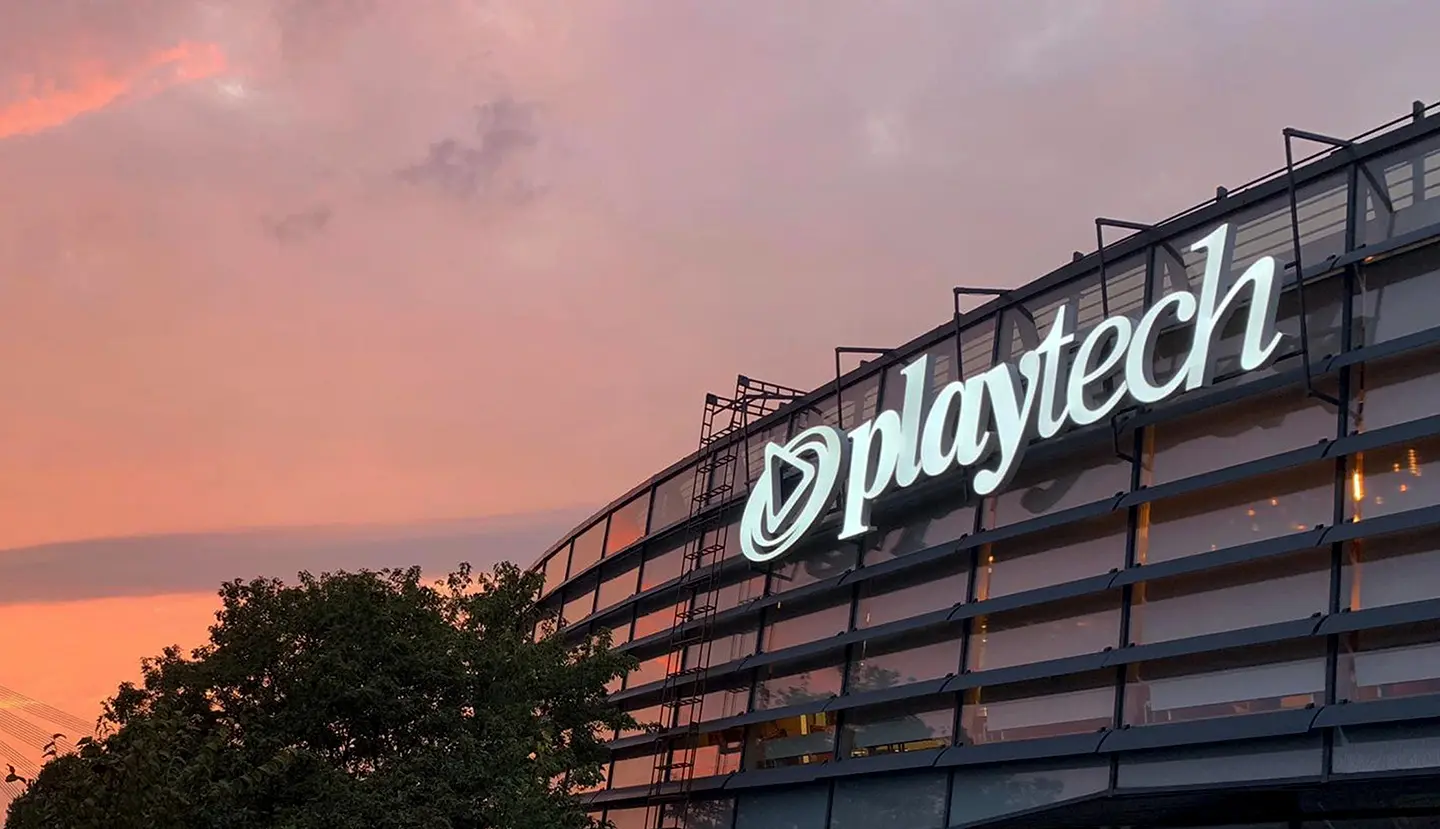 Exterior of Playtech office building illuminated at dusk.