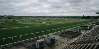 Empty British horse racing track with grandstands under overcast skies showing regulatory uncertainty