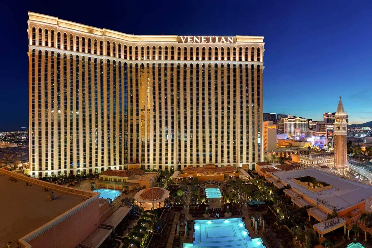 The Venetian Las Vegas resort exterior view at night, featuring pools and architecture.