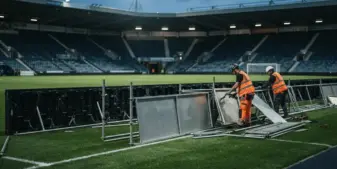 Empty stadium advertising boards being removed at a British football venue under new gambling regulations
