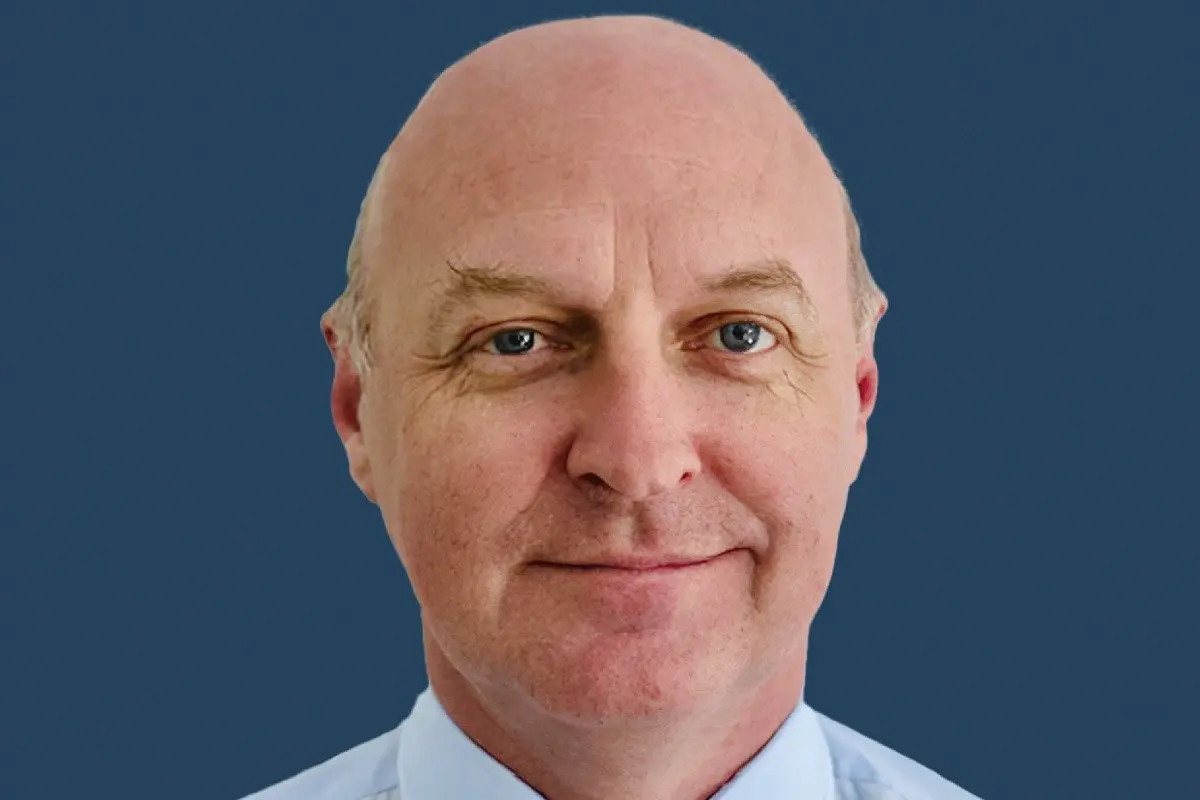 Headshot of Bruce Mathieson Jr against a solid blue background