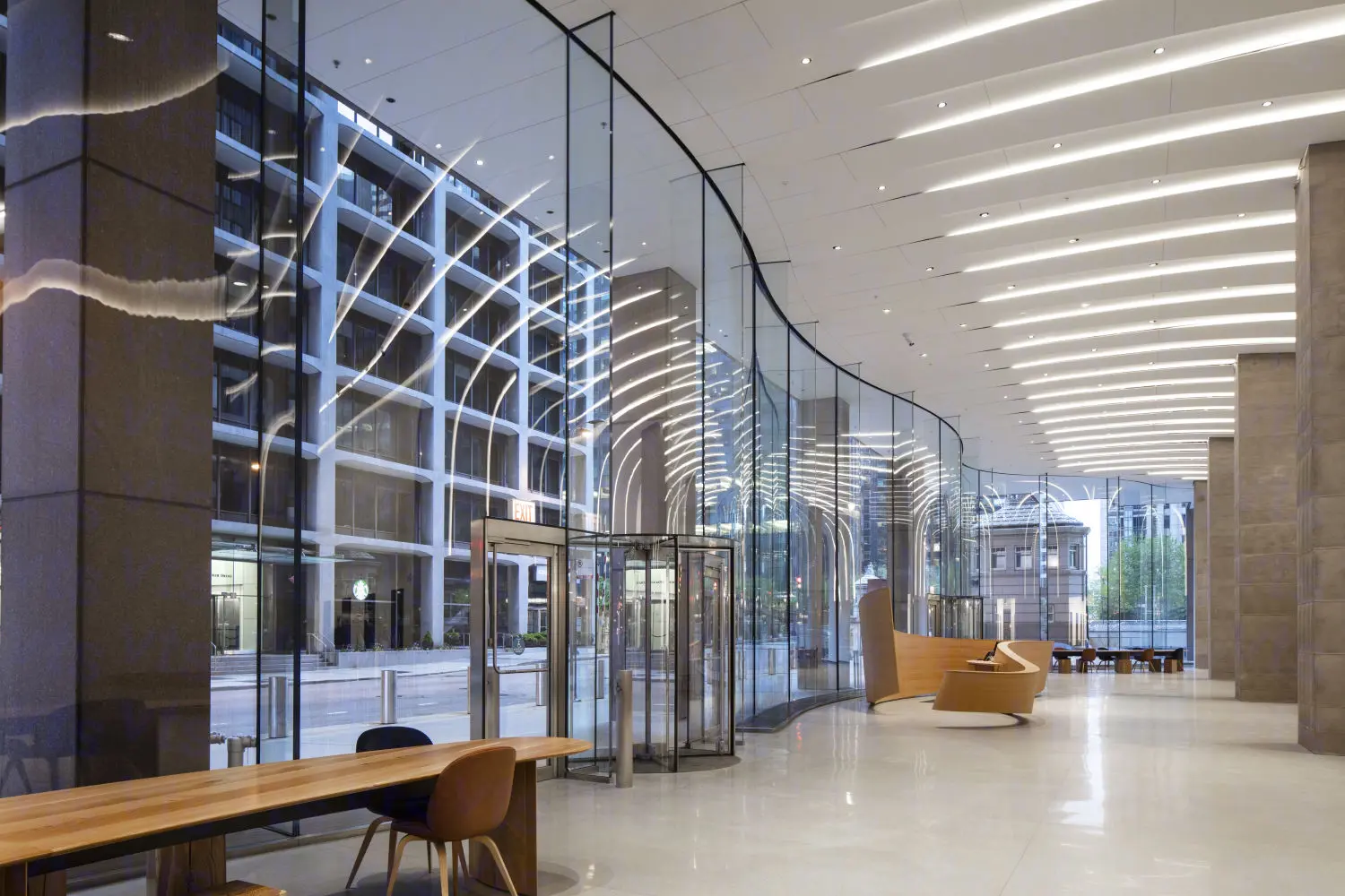 Modern interior lobby of the CME Group headquarters in Chicago with curved glass walls and linear ceiling lights