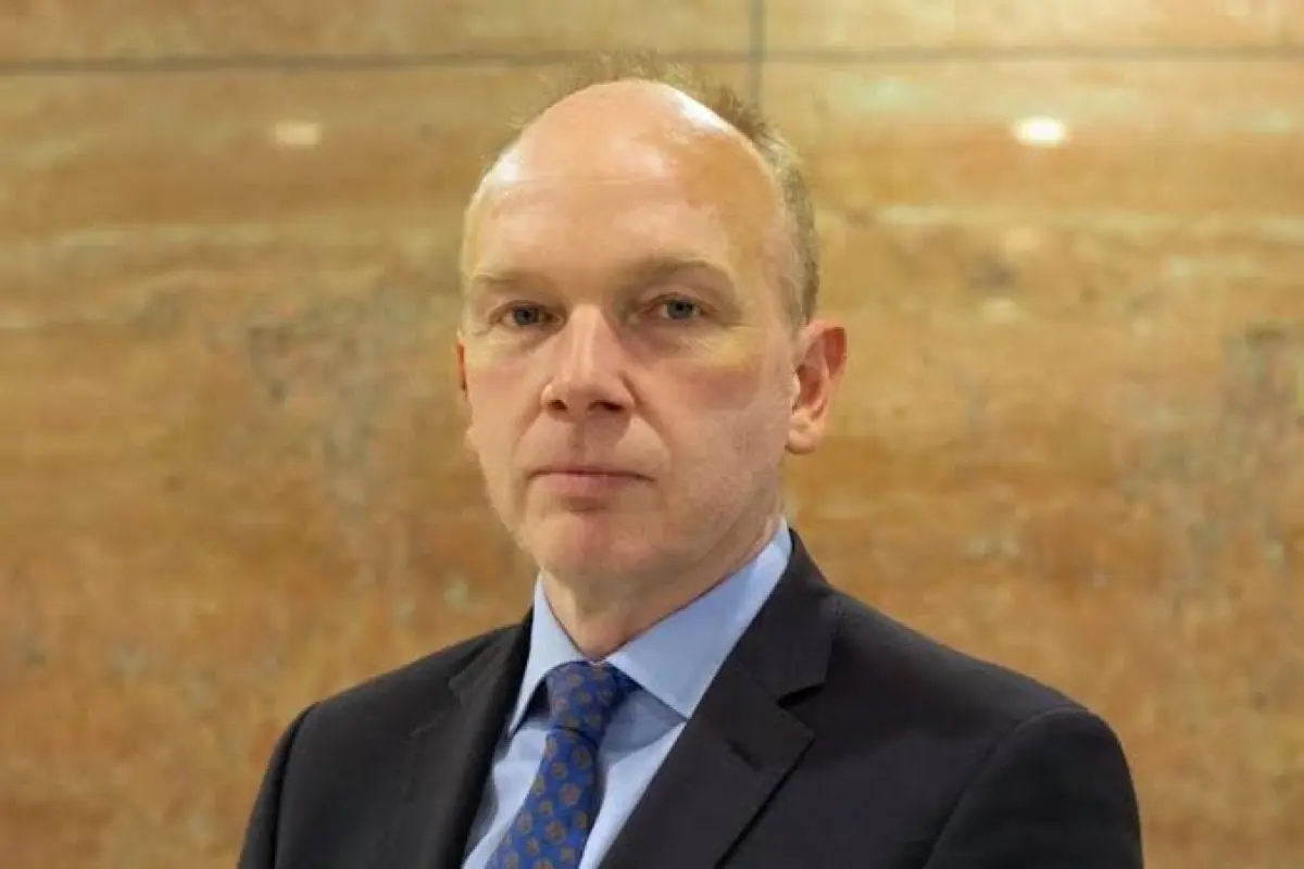 Portrait of Maarten Haijer wearing a dark navy suit and blue patterned tie