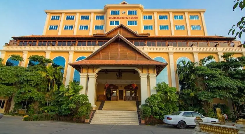 Exterior view of the Golden Sea Hotel & Casino building with yellow walls and tropical greenery