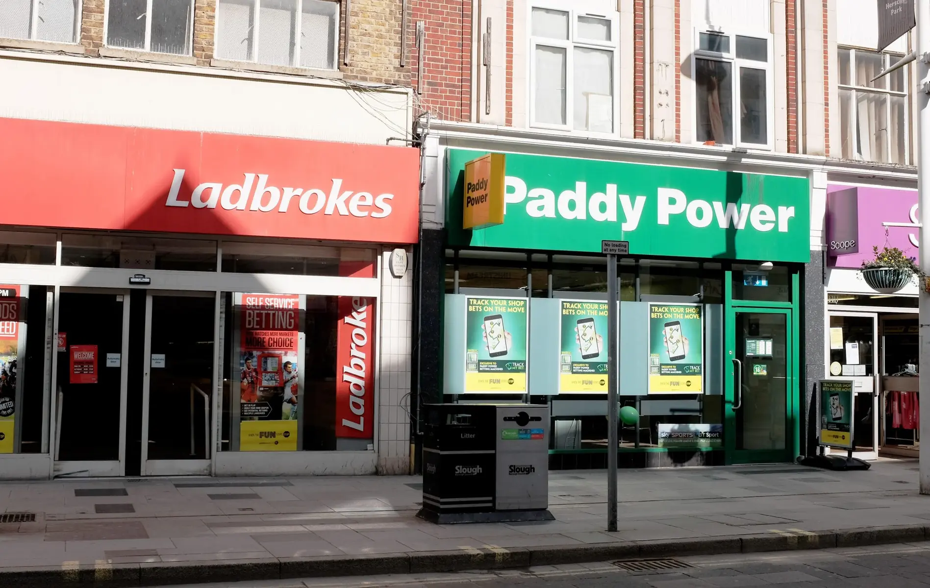 Ladbrokes and Paddy Power betting shops side-by-side on a UK high street.