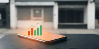 Smartphone showing rising gambling market data beside a closed betting shop
