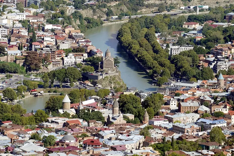 Panoramic view of Tbilisi city with the Kura River and historic churches.